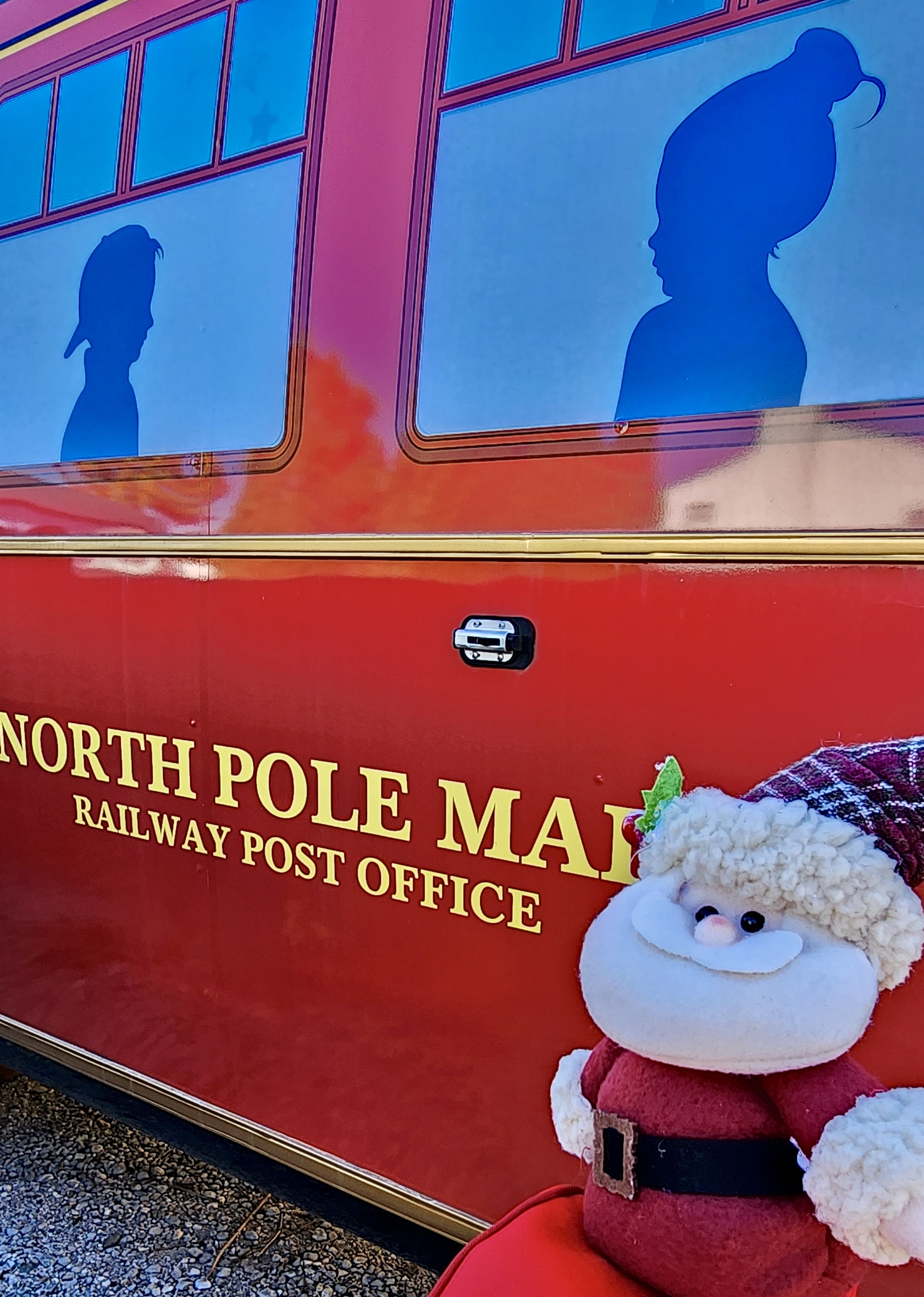 The Polar Express conductor and hobo in their festive uniforms, standing in front of the brightly lit train